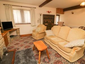 ein Wohnzimmer mit einem Sofa und 2 Stühlen in der Unterkunft Poppy Cottage in Settle