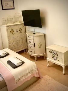 a bedroom with two beds and a tv and a dresser at Kwatera Prywatna Maja in Sopot