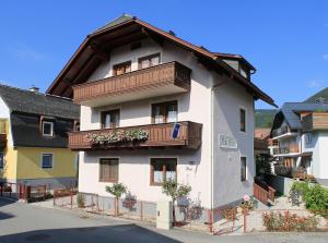 a large white building with a balcony at Haus Pitzer/Apartments Troicher in Schladming