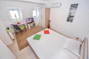 Cette petite chambre comprend un lit blanc et un bureau. dans l'établissement Bucharest Old Town Villa, à Bucarest