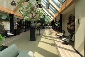 Hotel de Werelt في لونتيرين: ممر فيه كراسي ونباتات في مبنى