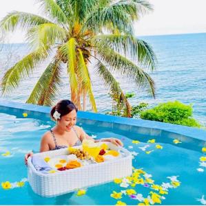 a woman sitting in a bath tub in the water at Bintana Sa Paraiso in Mambajao