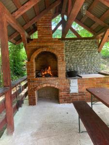 Una chimenea de ladrillo al aire libre con una mesa y un banco. en M Dey, en Vişeu de Sus