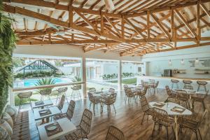 um restaurante com tectos e mesas e cadeiras de madeira em Ultra Mint Dive Resort em Panglao