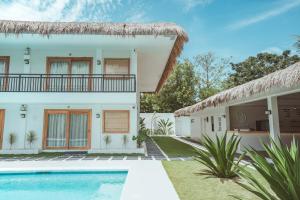 une villa avec une piscine en face d'une maison dans l'établissement Ultra Mint Dive Resort, à Panglao