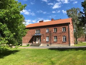 a red brick building with a sign on it at Hotelli Verstas in Nakkila
