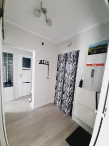 Pokój z białymi ścianami i drzwiami z zasłoną w obiekcie Apartament w Polanicy w Polanicy Zdroju