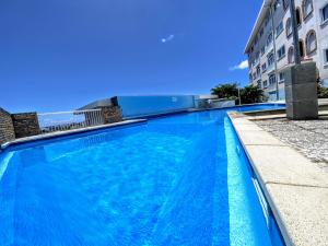 a large blue swimming pool next to a building at TAHITI - Orovini Cottage in Papeete