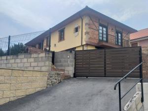a house with a wooden gate in front of it at LOS LAURELES in Cudón