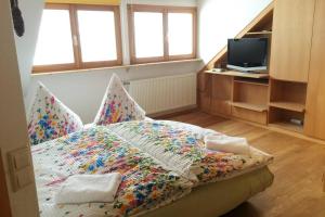 ein Schlafzimmer mit einem Bett mit einer bunten Decke in der Unterkunft Haus Wiesengrund-Fahl, FeWo 6 in Todtnau