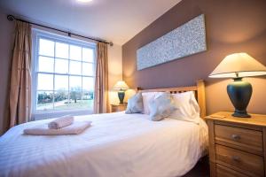 a bedroom with a white bed with a window at The Bell Inn in Frampton on Severn