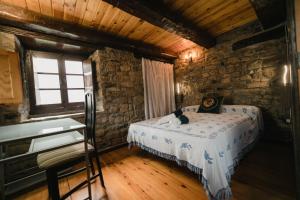 een slaapkamer met een bed in een stenen gebouw bij BORAU - Casa 150m2 con JARDÍN Y BARBACOA in Borau