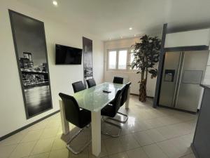 comedor con mesa de cristal y sillas negras en Chambres privées en colocations villeurbanne cusset, en Villeurbanne