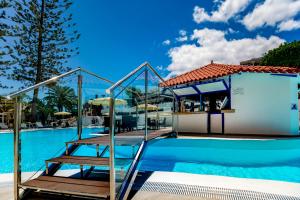 a swimming pool with a wooden staircase next to a building at Rey Carlos in Playa del Ingles