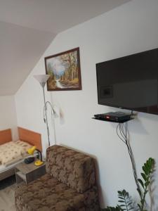 a living room with a chair and a flat screen tv at Penzión Nezábudka in Stropkov