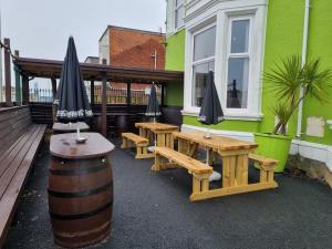 a patio with tables and umbrellas on a building at The Beechfield Hotel in Blackpool