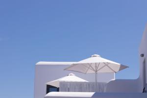 a white umbrella sitting on top of a table at Archon Seaside Retreat in Plaka