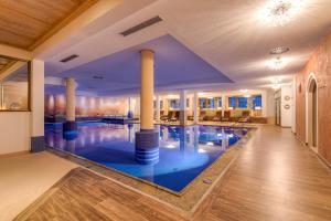 a large pool with columns in the middle of a building at Hotel Alpenhof in Tux