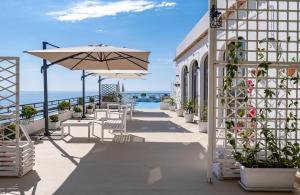 un patio con ombrellone, tavoli e sedie di Le Terrazze sul mare a Ustica
