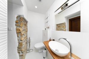 a bathroom with a sink and a stone wall at PB Apartments in Spišská Nová Ves +96 photos