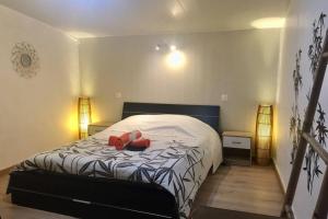 a bedroom with a bed with two red shoes on it at Magnifique maison 80m² avec extérieur in Saint-Michel-le-Cloucq