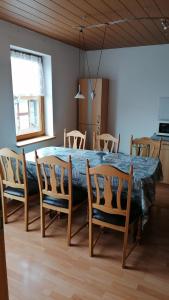 a dining room table with chairs and a blue table at Ferienwohnung Hase in Thale