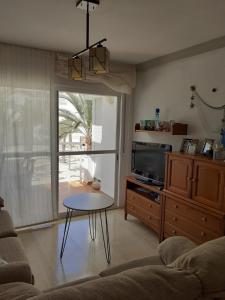 sala de estar con mesa y TV en Piso Carboneras Playa, en Carboneras