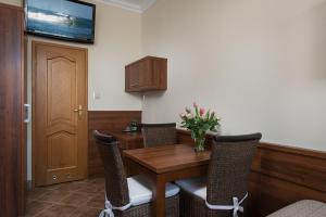 a dining room with a wooden table and chairs at Willa Korona in Hel