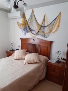 1 dormitorio con 1 cama con mosquiteros en la pared en Piso Carboneras Playa, en Carboneras