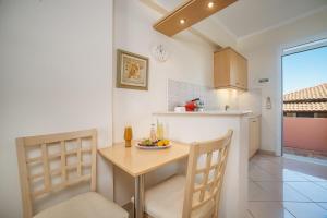 cocina con mesa pequeña, sillas y barra en Marietta Boutique Apts, en Tsilivi