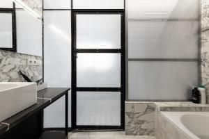 ein Badezimmer mit einer weißen Badewanne und einem Waschbecken in der Unterkunft Casa Creu Mar in Sant Feliu de Guixols + 25 Fotos