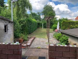 a garden with a brick wall and a pathway at Ferienwohnung „ Zum Josefstal „ in Sankt Ingbert