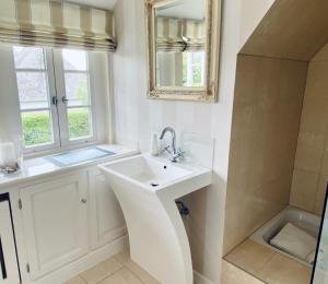 a white bathroom with a sink and a mirror at Sylt-Traum Möwe in Keitum