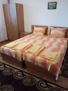 a bedroom with a bed with a colorful comforter at Къща за гости Петрови in Primorsko