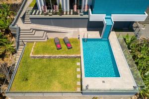 an overhead view of a swimming pool with two red chairs at Sonho do Oceano in Ribeira Brava