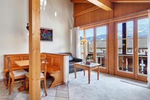 een woonkamer met een piano en een tafel bij Hotel Zugspitze in Garmisch-Partenkirchen