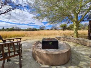 a fire pit with a clock on it next to a bench at Zebula 5 Bedroom, sleeps12 IZN1 in Mabula