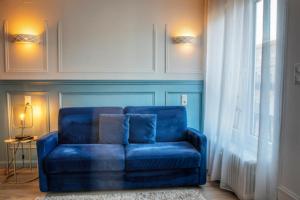 a blue couch in a living room with a window at Goodtime Apartments Strasbourg in Strasbourg