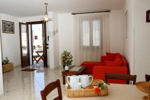 a living room with a red couch and a table at B&B Minerva in Castro di Lecce