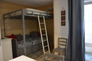 um quarto com beliches, uma escada e uma cadeira. em Studio MARMOTTE FONT-ROMEU 4 personnes avec balcon Résidence VAL SOLEIL entièrement rénové en juin 2021 place de PARKING & WIFI gratuit , draps & serviettes de toilettes non inclus, sabanas y toallas no incluidos em Font Romeu Odeillo Via