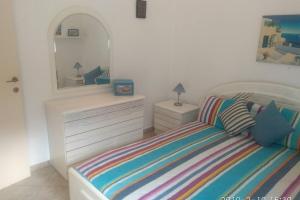 ein Schlafzimmer mit einem Bett mit einer Kommode und einem Spiegel in der Unterkunft Blue Velvet apartment in Paránimfoi