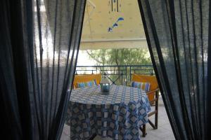 uma mesa com uma toalha de mesa azul e branca numa varanda em Blue Velvet apartment em Paránimfoi