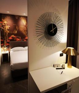 una camera da letto con un orologio a muro e un letto di Hotel Up Wellness & Spa a Foggia