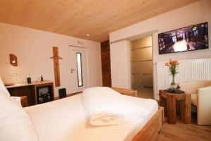ein Schlafzimmer mit einem Bett und einem TV an der Wand in der Unterkunft Hotel-Restaurant Gasthaus Bonimeier in Niedergottsau