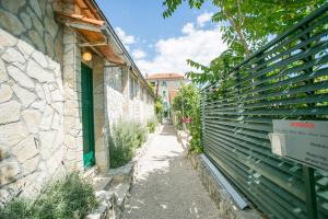 a narrow alley with a stone wall next to a building at Garden Apartment Hotel in Split