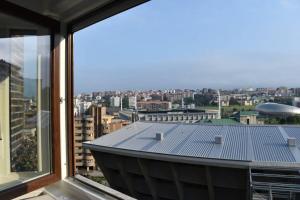 uma vista para o telhado de um edifício a partir de uma janela em Apartamento cerca de la playa em Santander