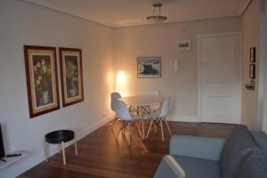 uma sala de estar com um sofá, uma mesa e cadeiras em Apartamento cerca de la playa em Santander