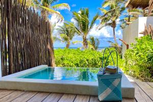a swimming pool with a basket next to a fence at Cabanas Tulum- Beach Hotel & Spa in Tulum