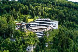 a building on the side of a mountain with trees at Sporthotel am Semmering in Semmering