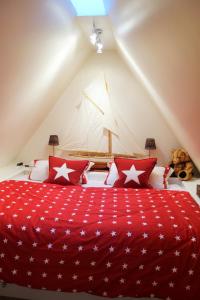 a bedroom with a red bed with red and white pillows at Sylt-Traum Möwe in Keitum